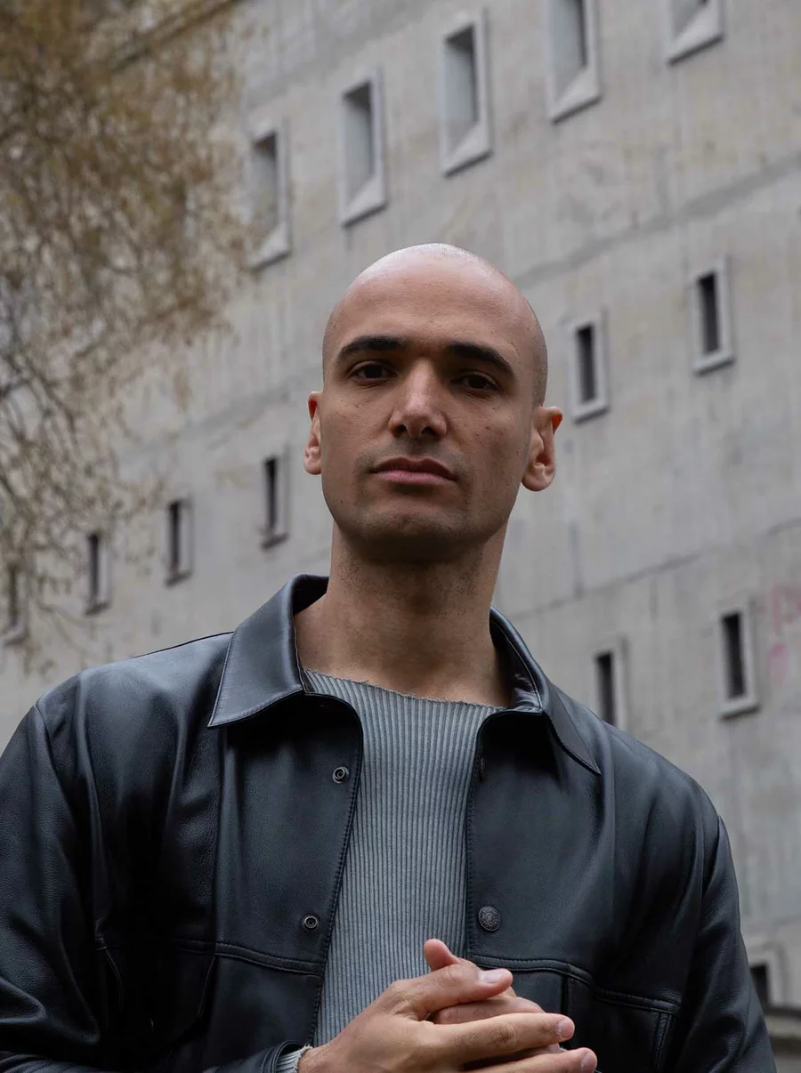 Raoul Zoellner im Porträt vor der markanten Bunkerwand, in Lederjacke und mit direktem Blick in die Kamera.
