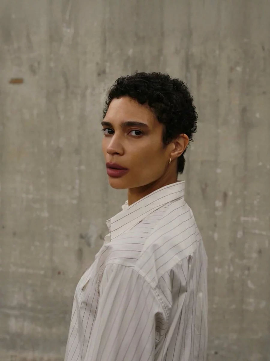 Chyn vom Team der Boros Collection vor einer rohen Betonwand des Bunkers, im Profil mit direktem Blick zur Kamera.