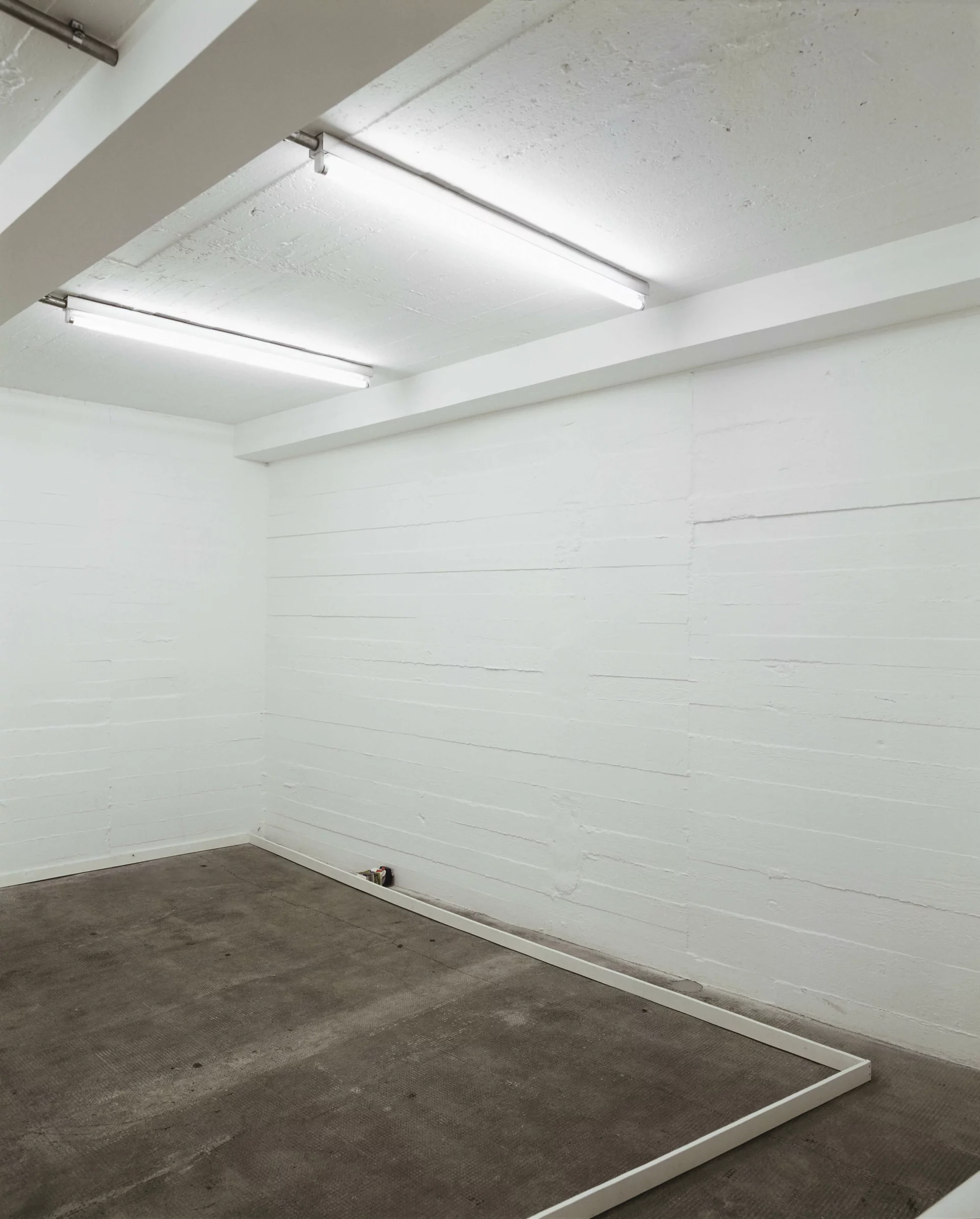 Leerer, weißer Ausstellungsraum mit Bodenrahmen und Wandöffnung, minimalistische Rauminstallation.