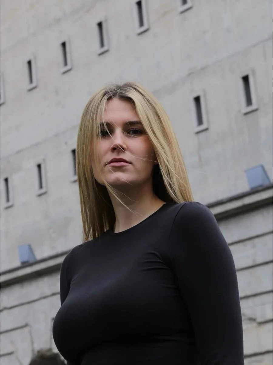 Lina steht im schwarzen Oberteil vor dem denkmalgeschützten Gebäude der Boros Collection in Berlin