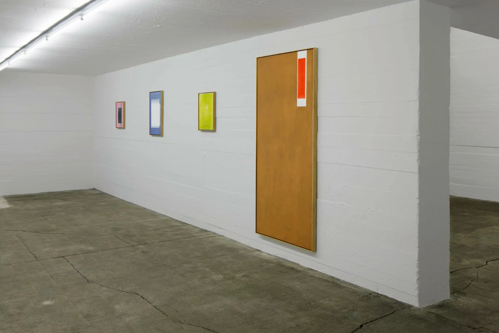 Vier abstrakte Werke von Marieta Chirulescu hängen nebeneinander an einer weißen Wand in einem Ausstellungsraum; jedes Bild zeigt farbige Flächen, Raster oder Rahmen in leicht digital wirkender Ästhetik.