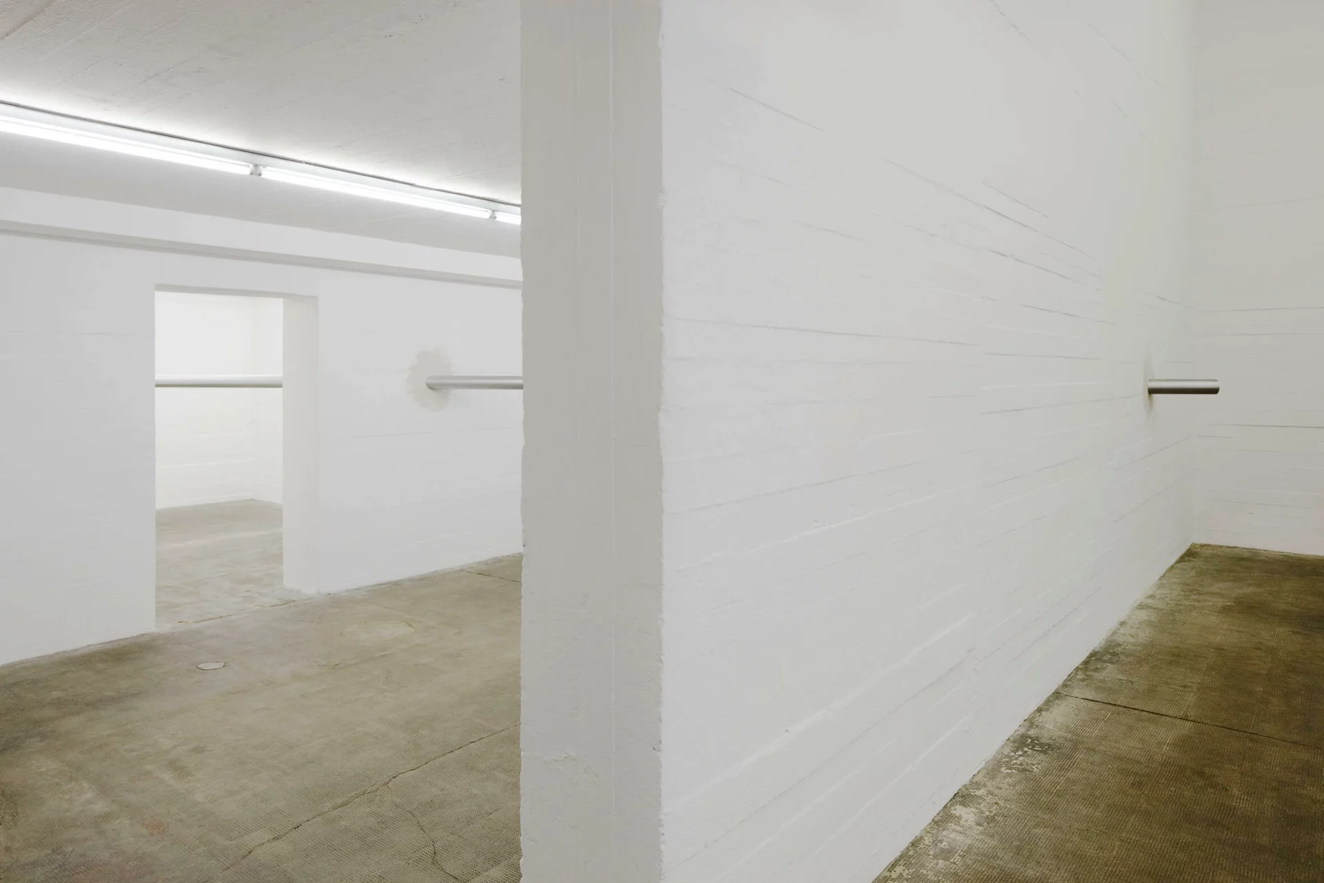 Awst & Walthers Latent Measures / Component 28 (2012) zeigt zwei Metallzylinder, die aus gegenüberliegenden Wänden ragen und Raum verbinden.