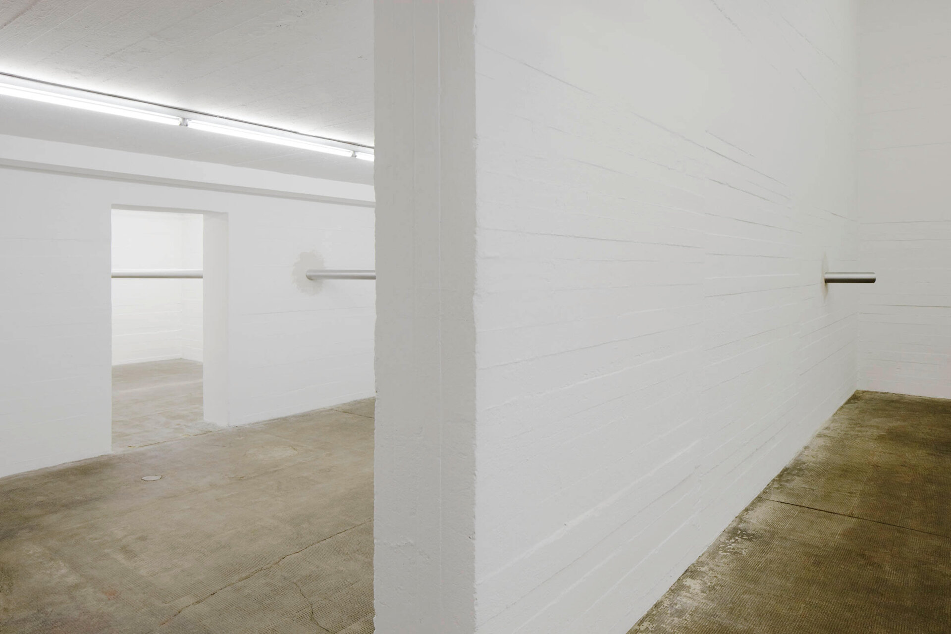 Awst & Walthers Latent Measures / Component 28 (2012) zeigt zwei Metallzylinder, die aus gegenüberliegenden Wänden ragen und Raum verbinden.