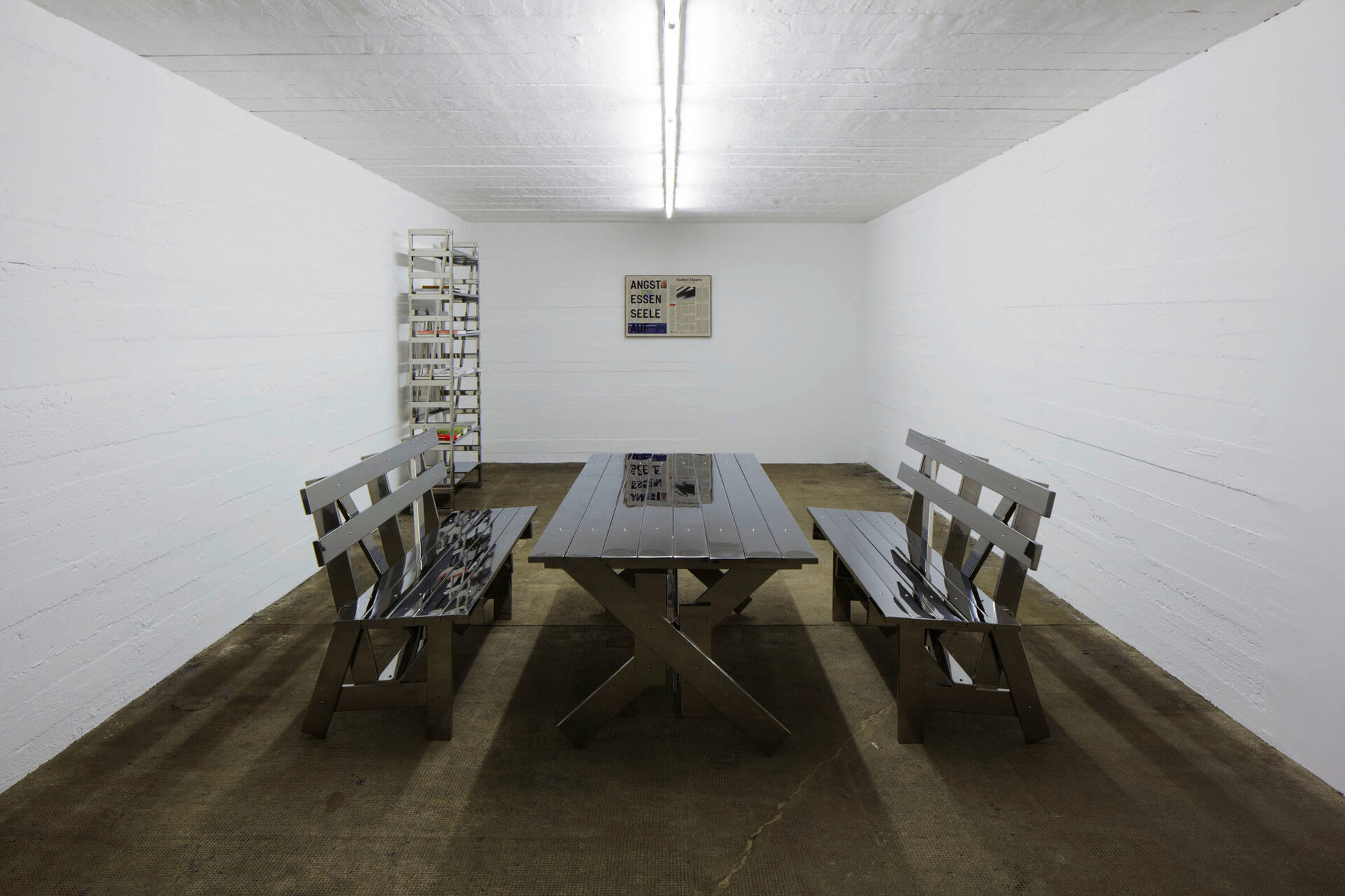 Installationsansicht eines minimalistischen Edelstahl-Möbelensembles von Rirkrit Tiravanija, bestehend aus Tisch, Bänken und Regal in einem weißen Raum der Boros Collection.