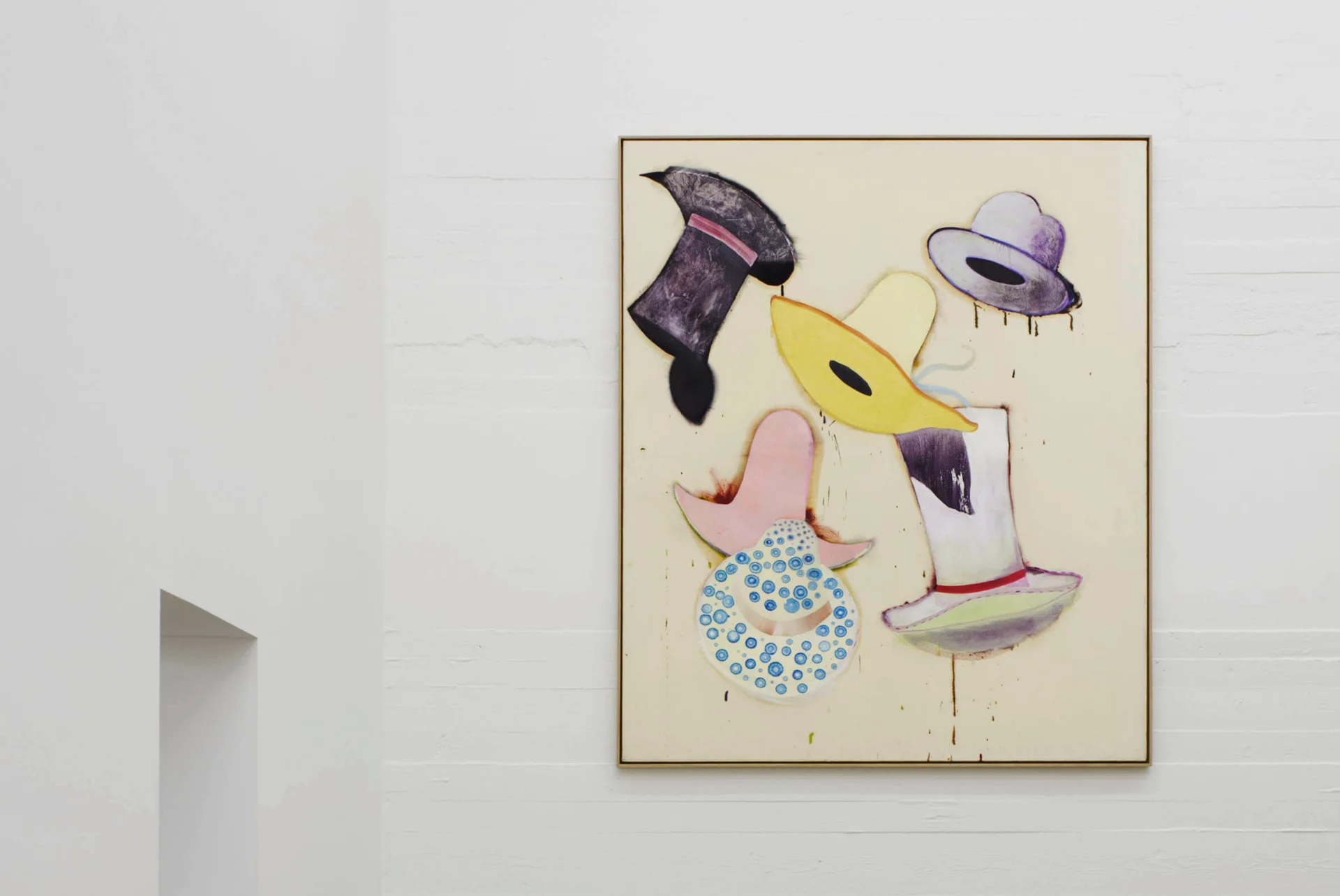 Gemälde von Florian Meisenberg mit schwebenden, farbigen Hüten auf hellem Grund; das Bild hängt an einer weißen Wand in einem minimalistisch gehaltenen Raum mit Sichtbetonboden.