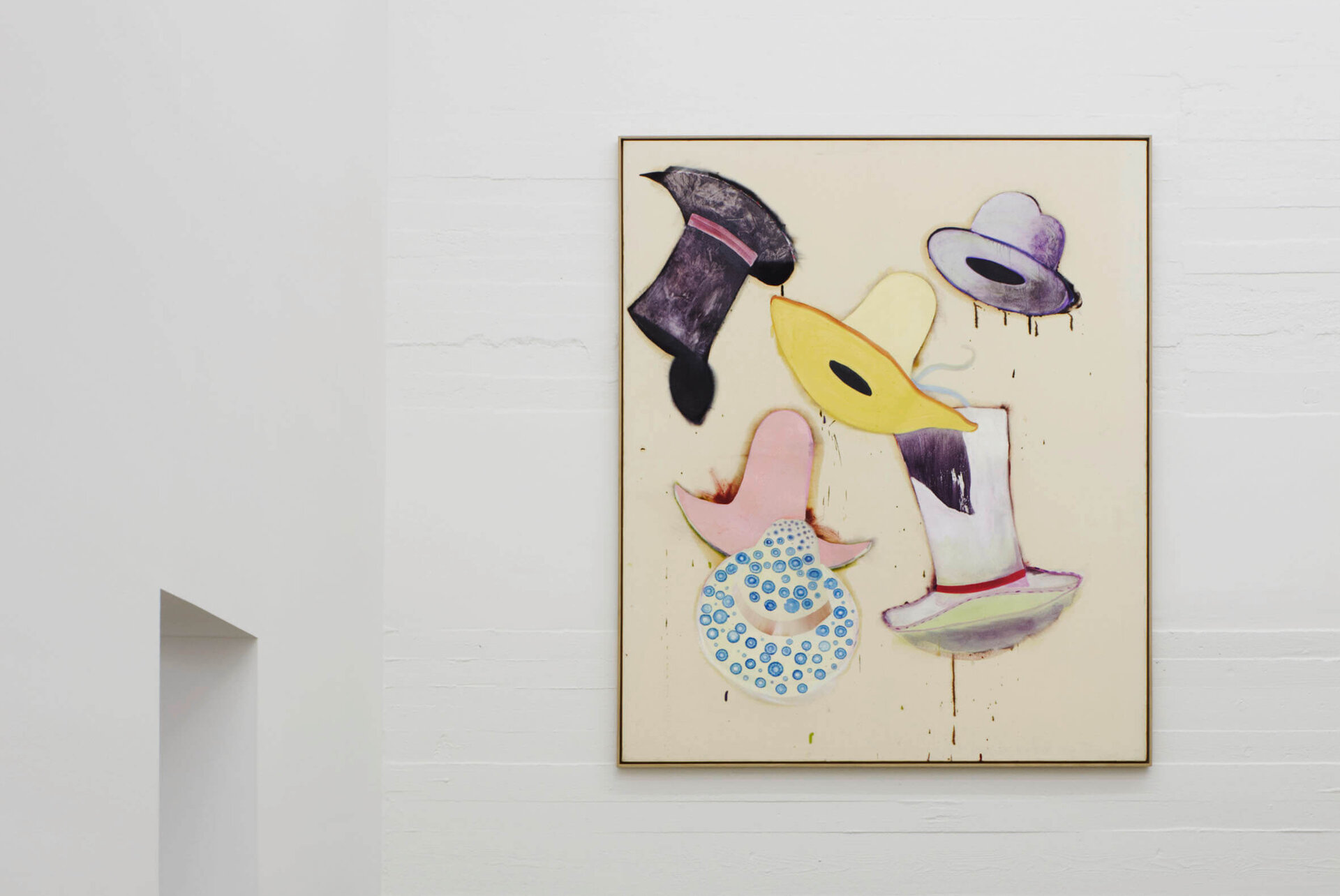 Gemälde von Florian Meisenberg mit schwebenden, farbigen Hüten auf hellem Grund; das Bild hängt an einer weißen Wand in einem minimalistisch gehaltenen Raum mit Sichtbetonboden.