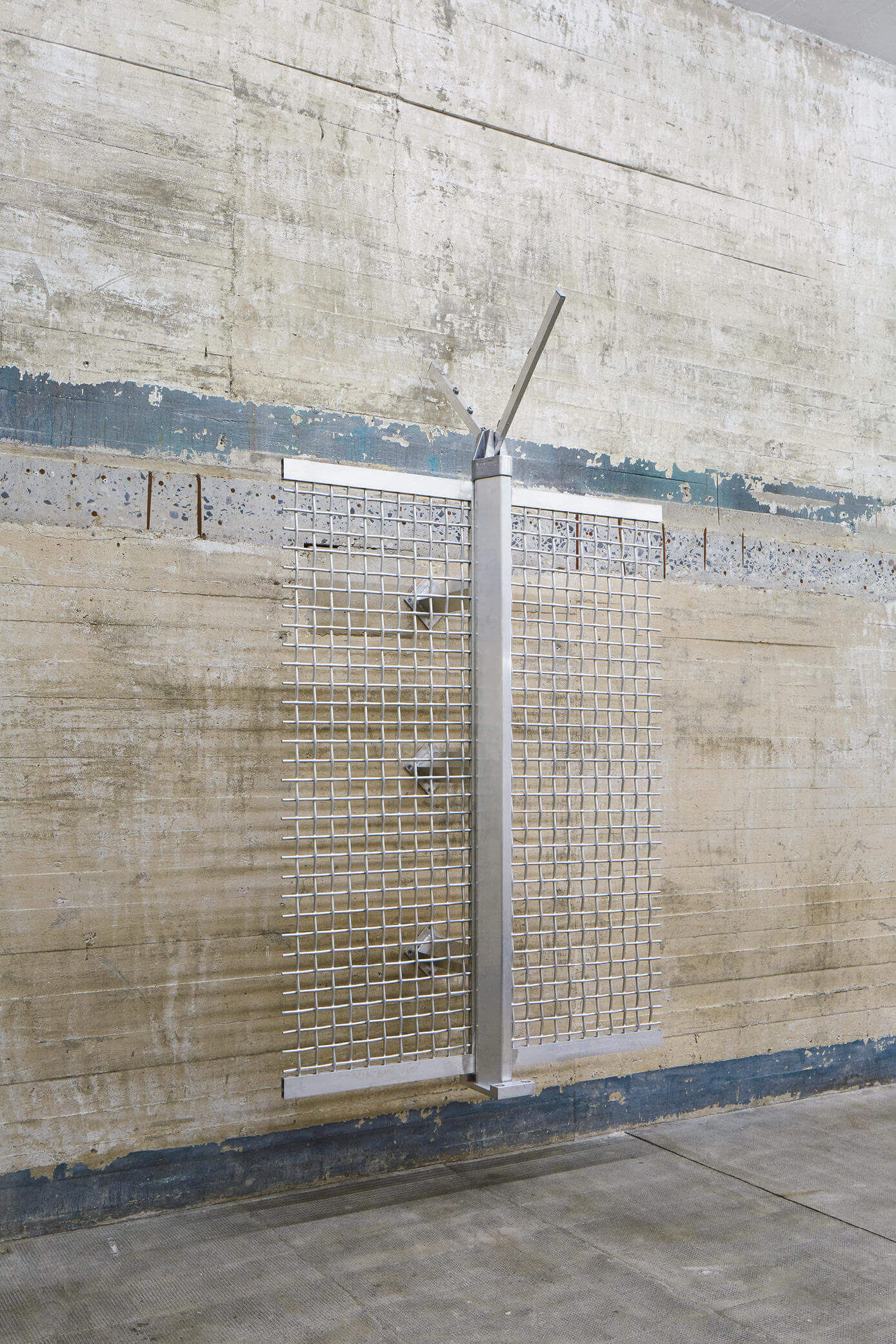 Metallskulptur aus Edelstahlgittern und zentralem Pfosten, montiert an Betonwand – Werk von Yngve Holen in der Boros Collection.